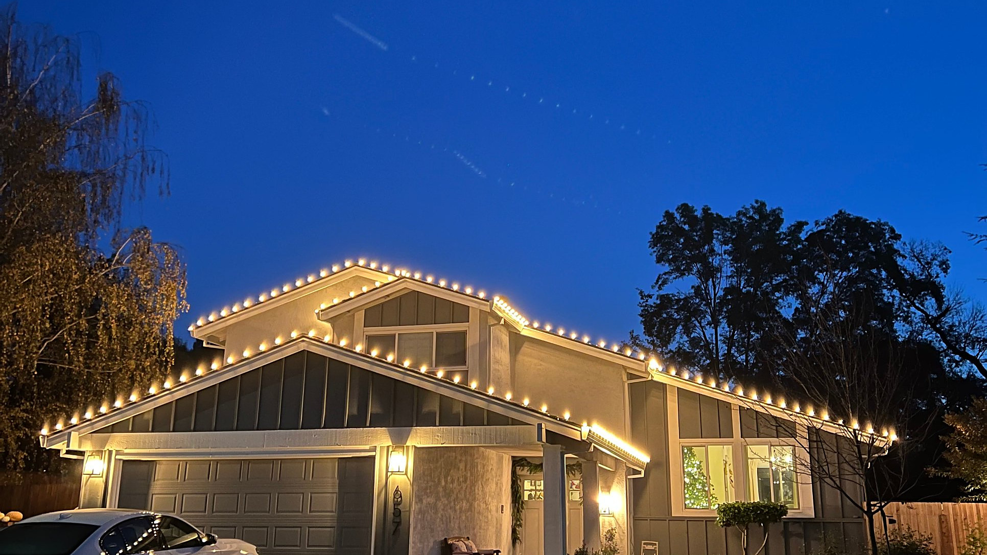 Roofline lighting installed by Louis's Exterior Services, photographed at dusk